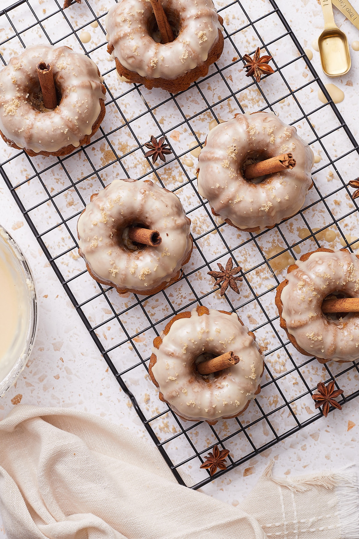 finished glazed Mini Bundt Cakes on a wire rack over a white counter top