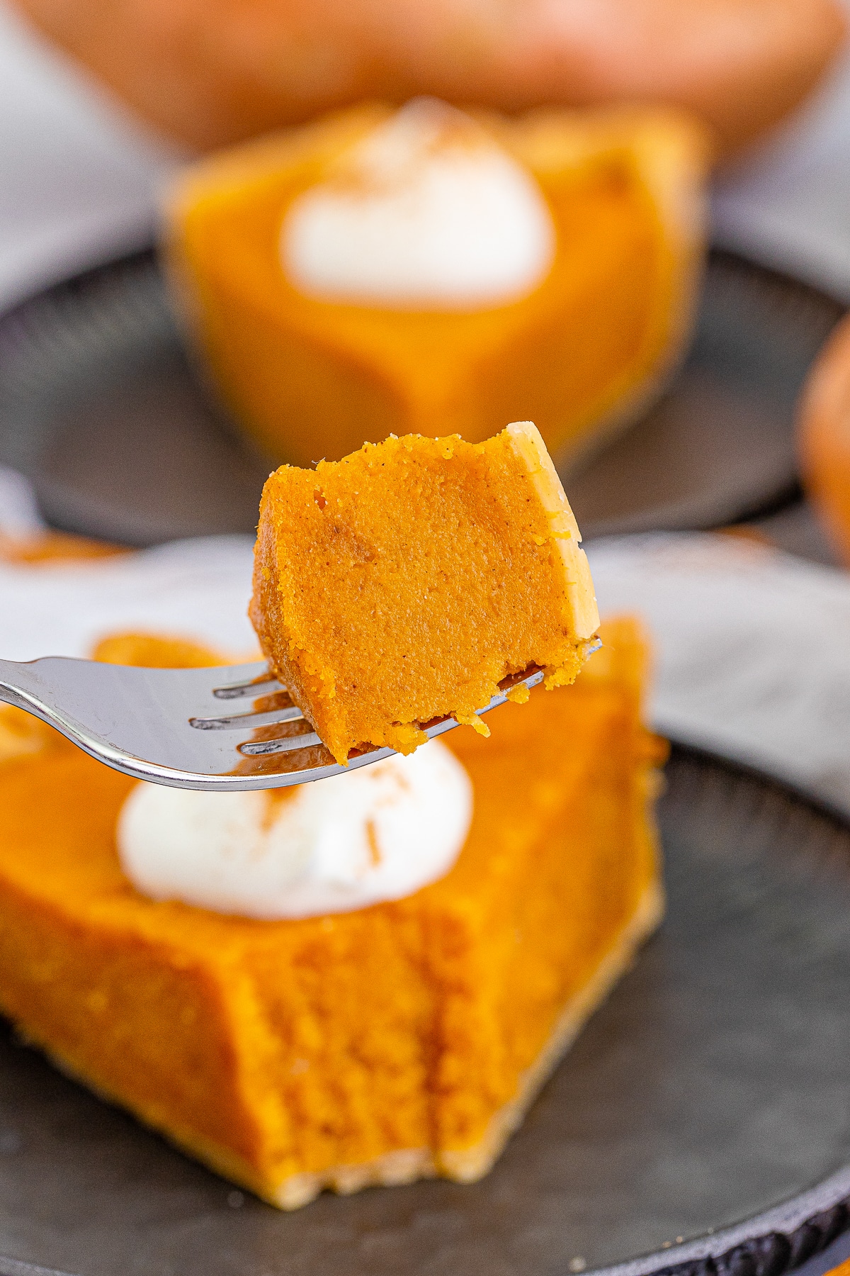 a fork holding up a bite of Sweet Potato Pie in air