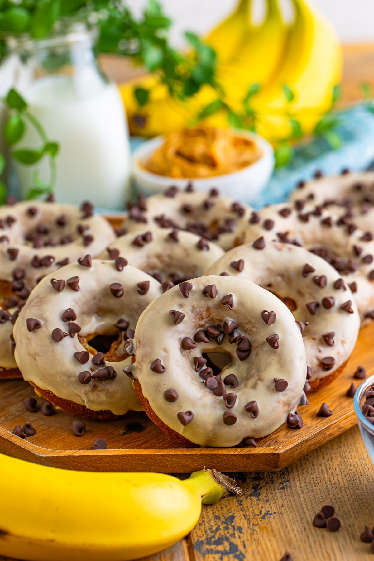 lots of Banana Donuts sitting out on a serving tray