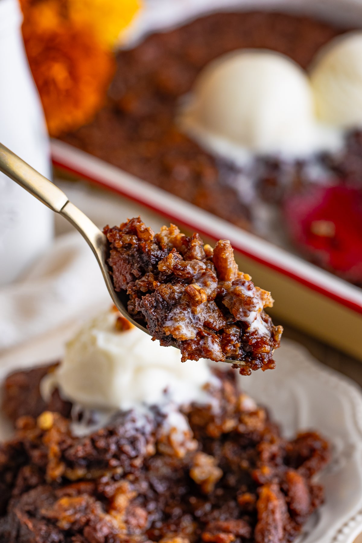 a spoon holding up a bite of Pecan Cobbler in air