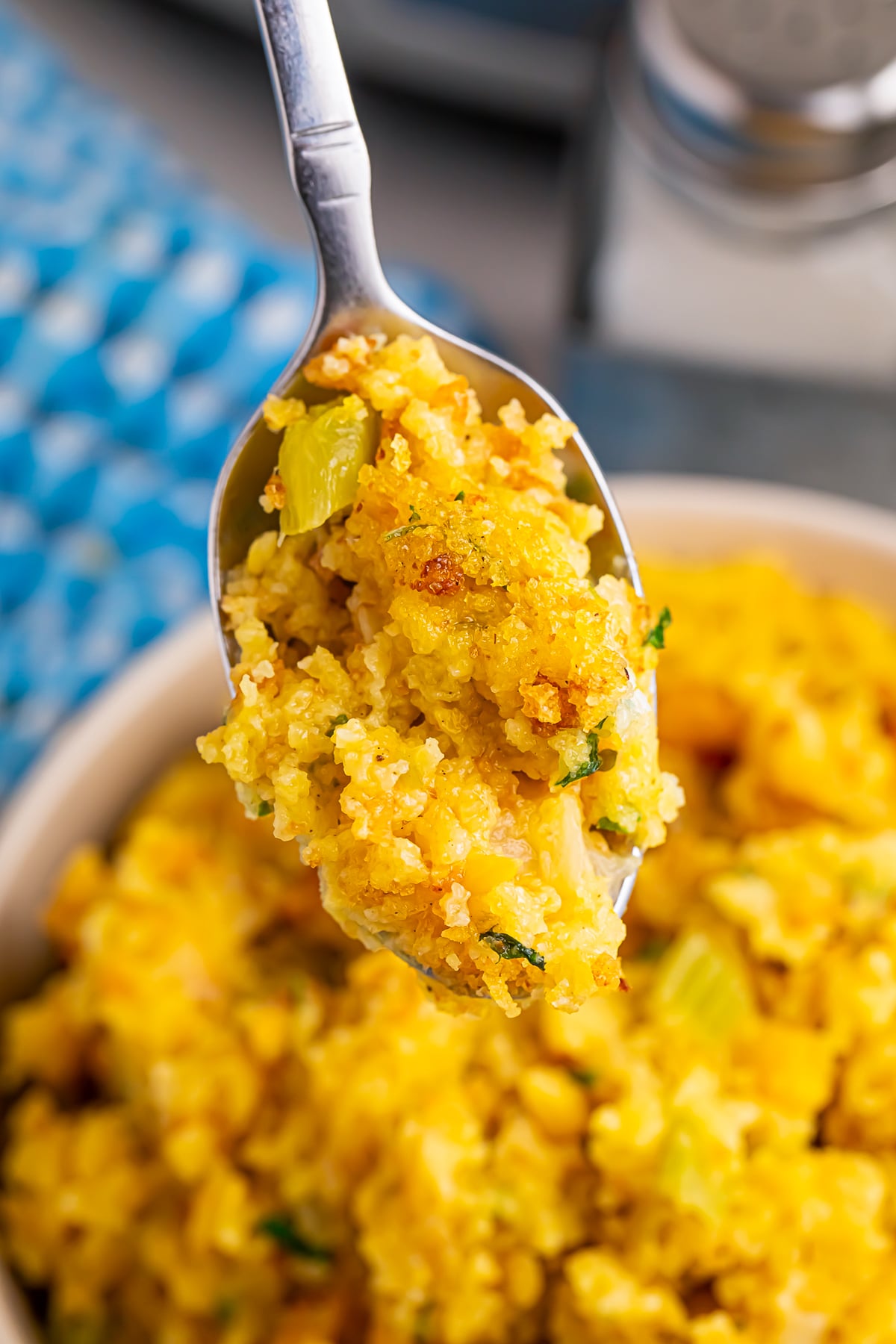 a spoon holding up a bite of Cornbread Dressing in air