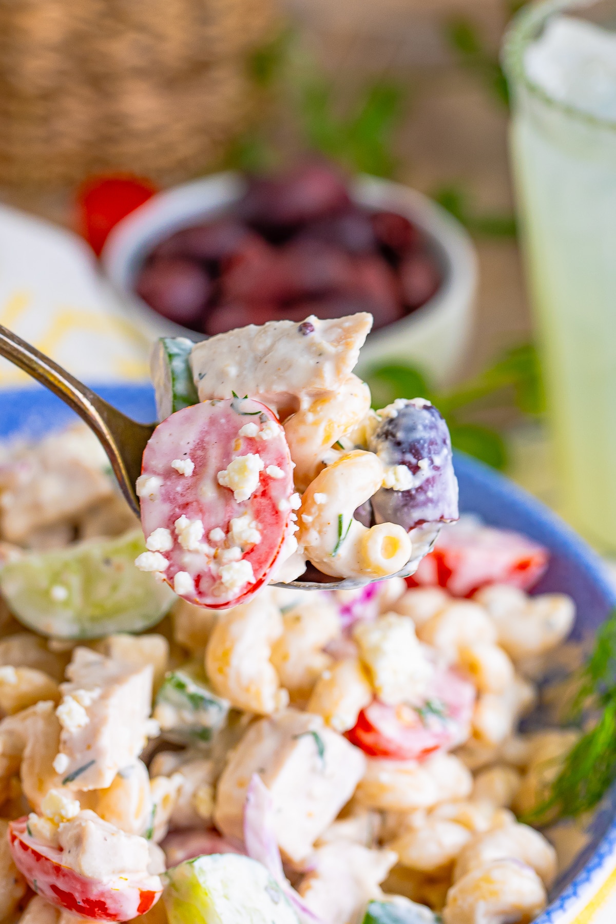 a spoon holding up a bite of Greek Pasta Salad Recipe in air