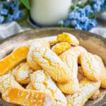 Homemade Lady Finger Cookies Recipe stacked on a serving plate, light and crunchy golden cookies dusted with powdered sugar ready to serve with coffee or layer into tiramisu.