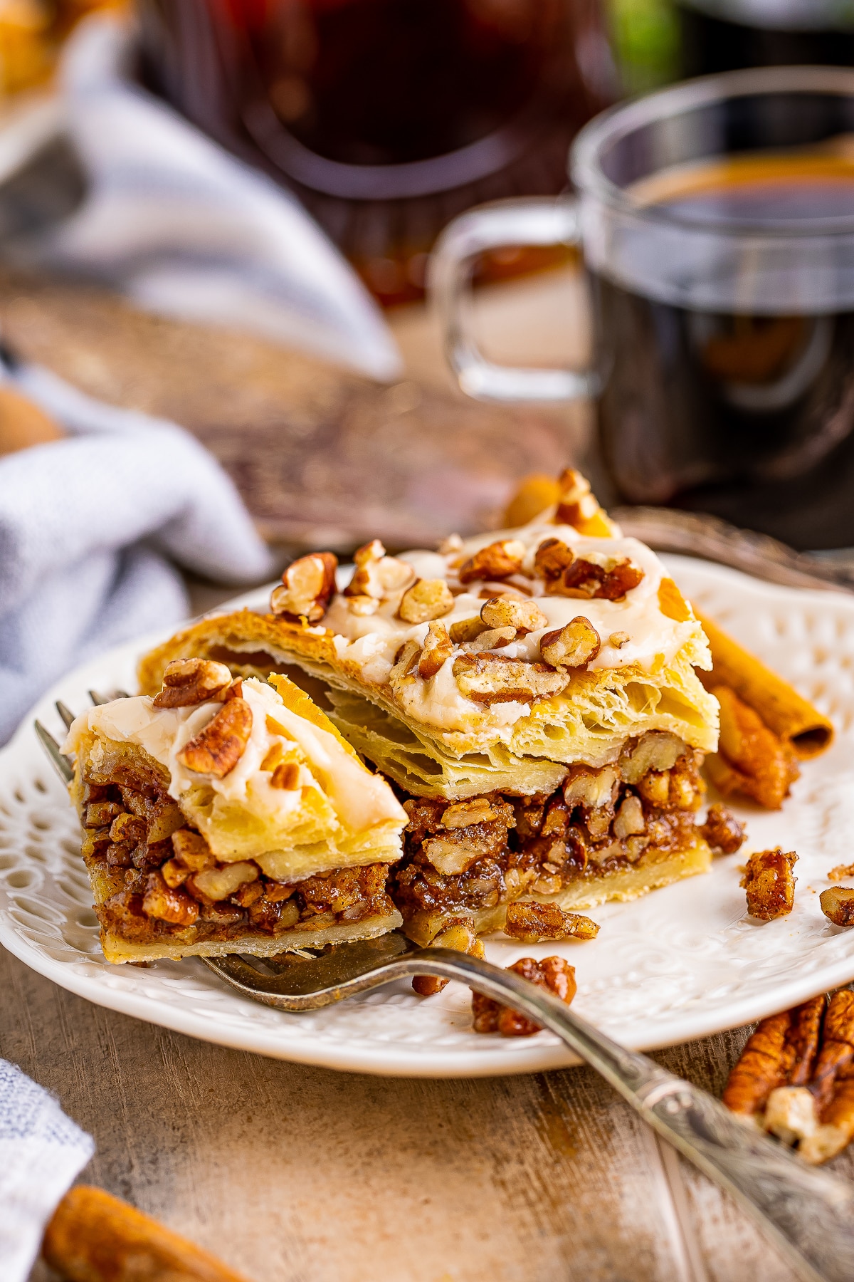 Pecan Pastry slice that has been cut in half on a tan plate to show interior