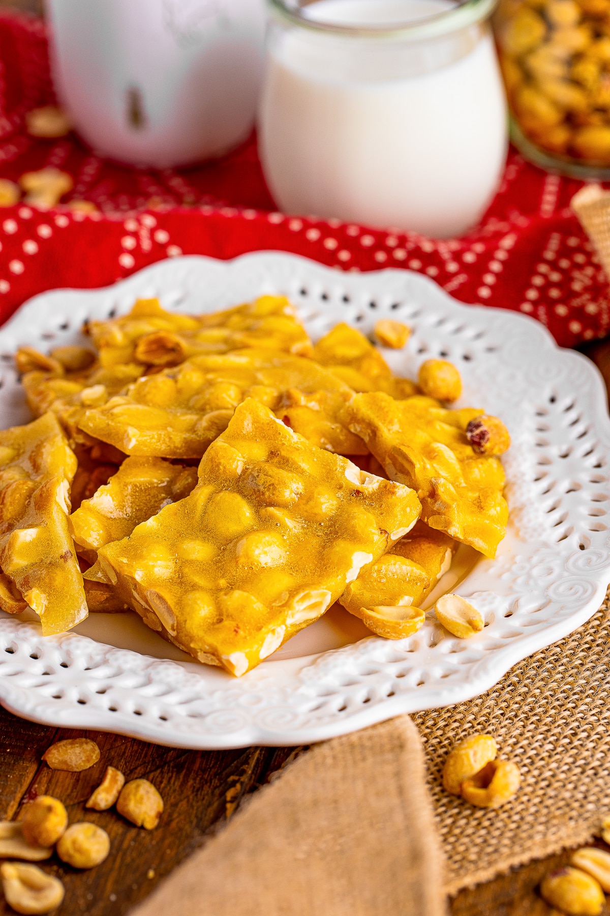 pieces of Microwave Peanut Brittle served on a white plate with red linen