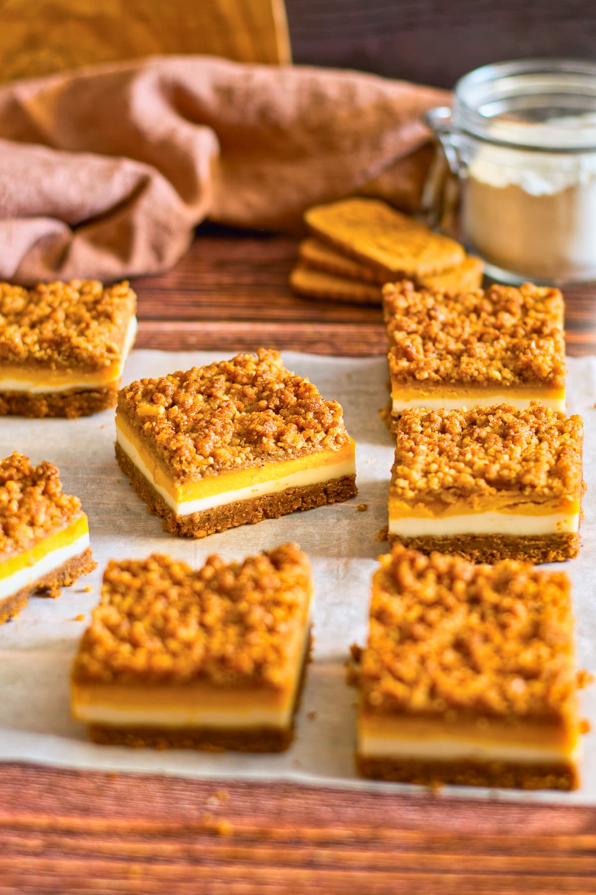 Pumpkin Cheesecake Bars cut into squares on parchment
