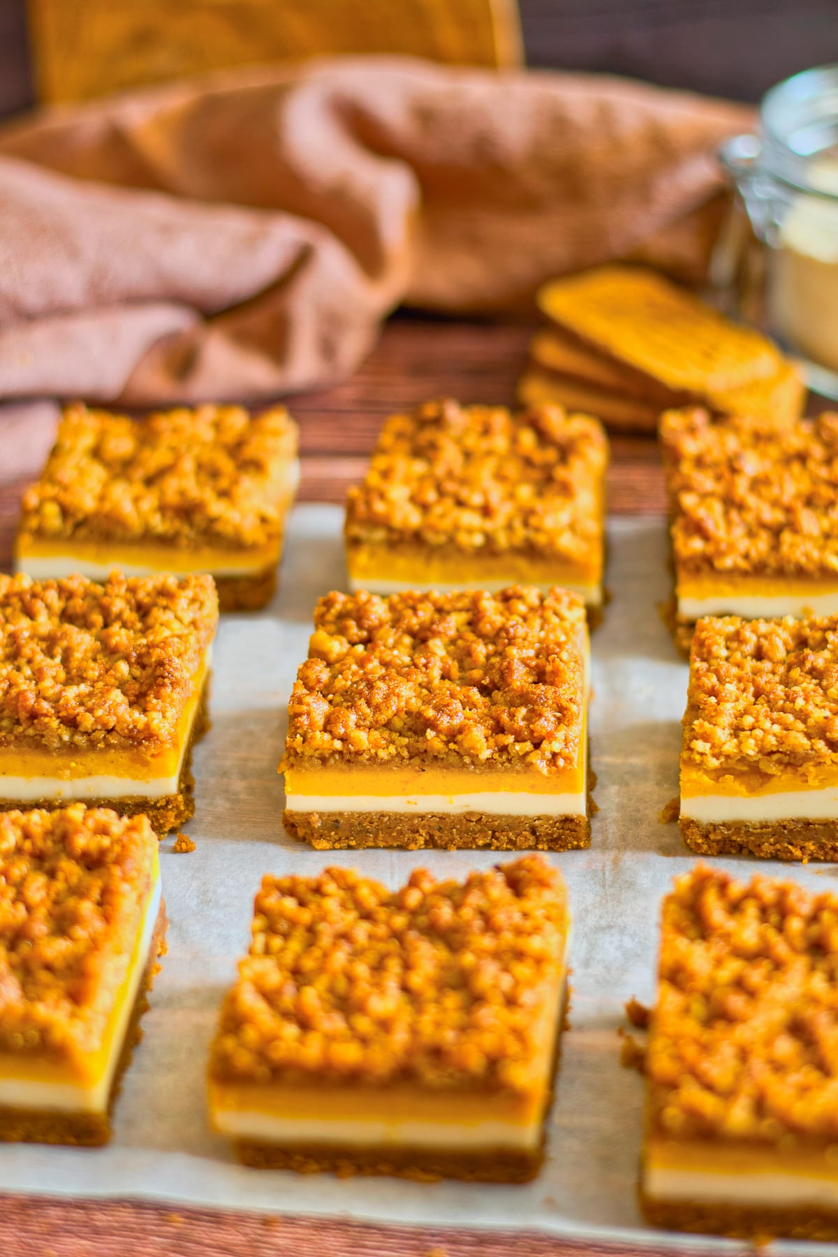 Pumpkin Cheesecake Bars cut into squares on parchment paper