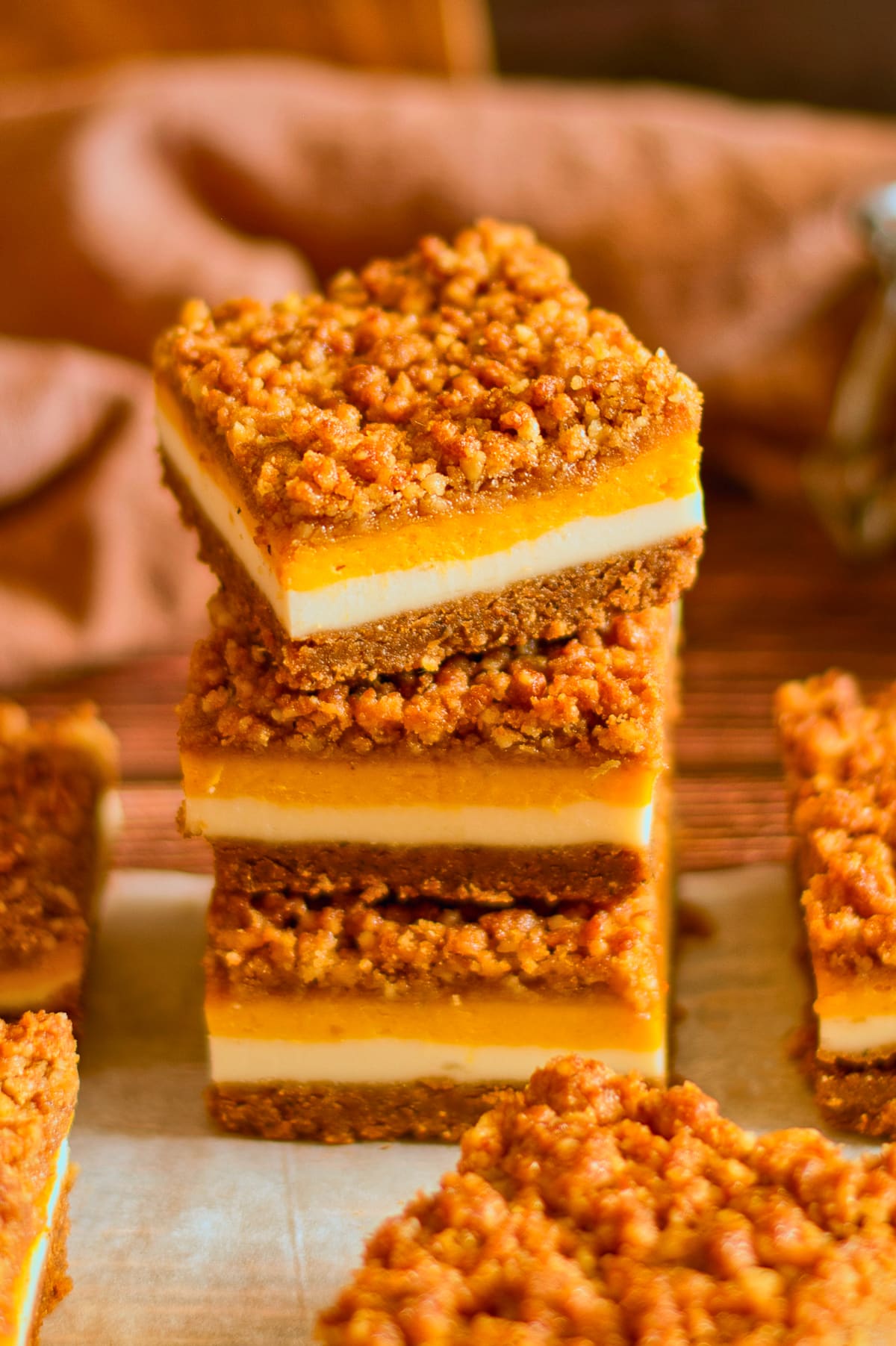 three Pumpkin Cheesecake Bars stacked on top of each other