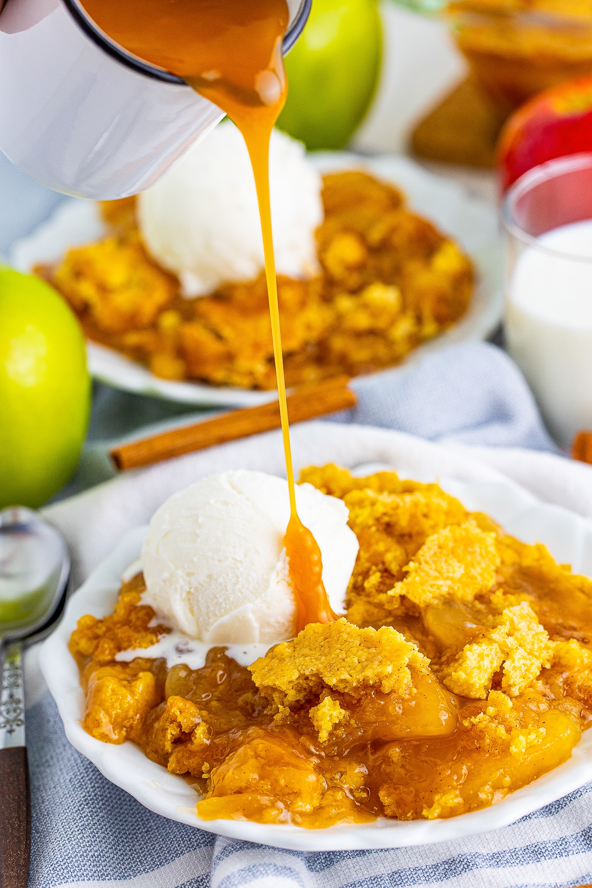 caramel sauce being poured over a portion of Caramel Apple Dump Cake
