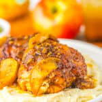 Apple Cider Chicken thigh glazed and golden over mashed potatoes with tender apple slices.