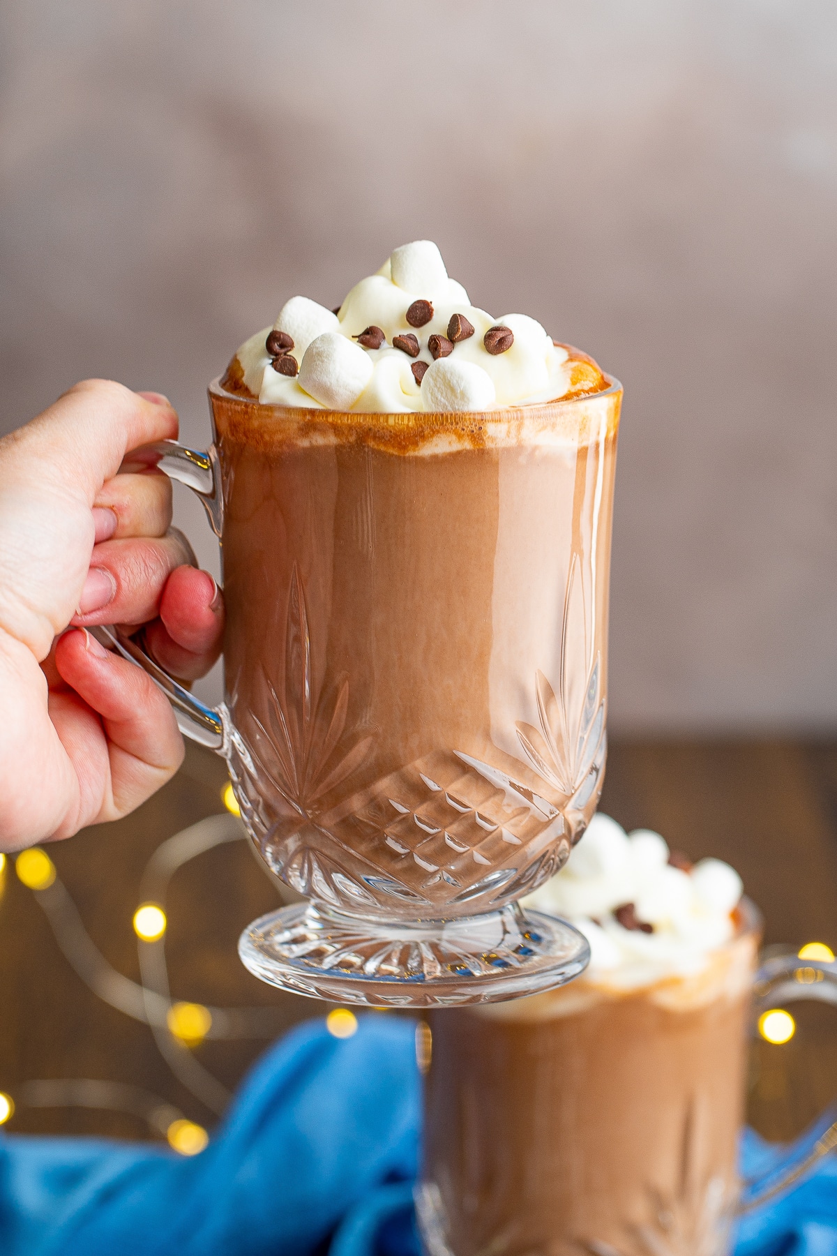 a hand holding up a glass of Boozy hot chocolate  in air
