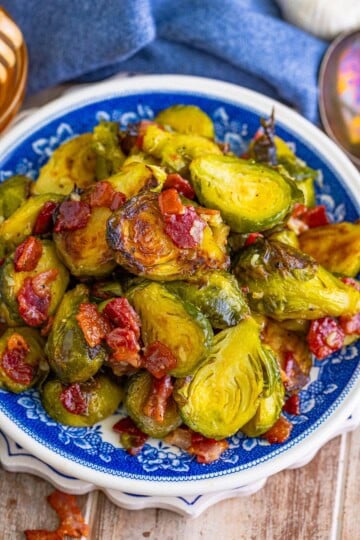 Glazed Roasted Brussel Sprouts with Bacon served in a blue and white bowl.