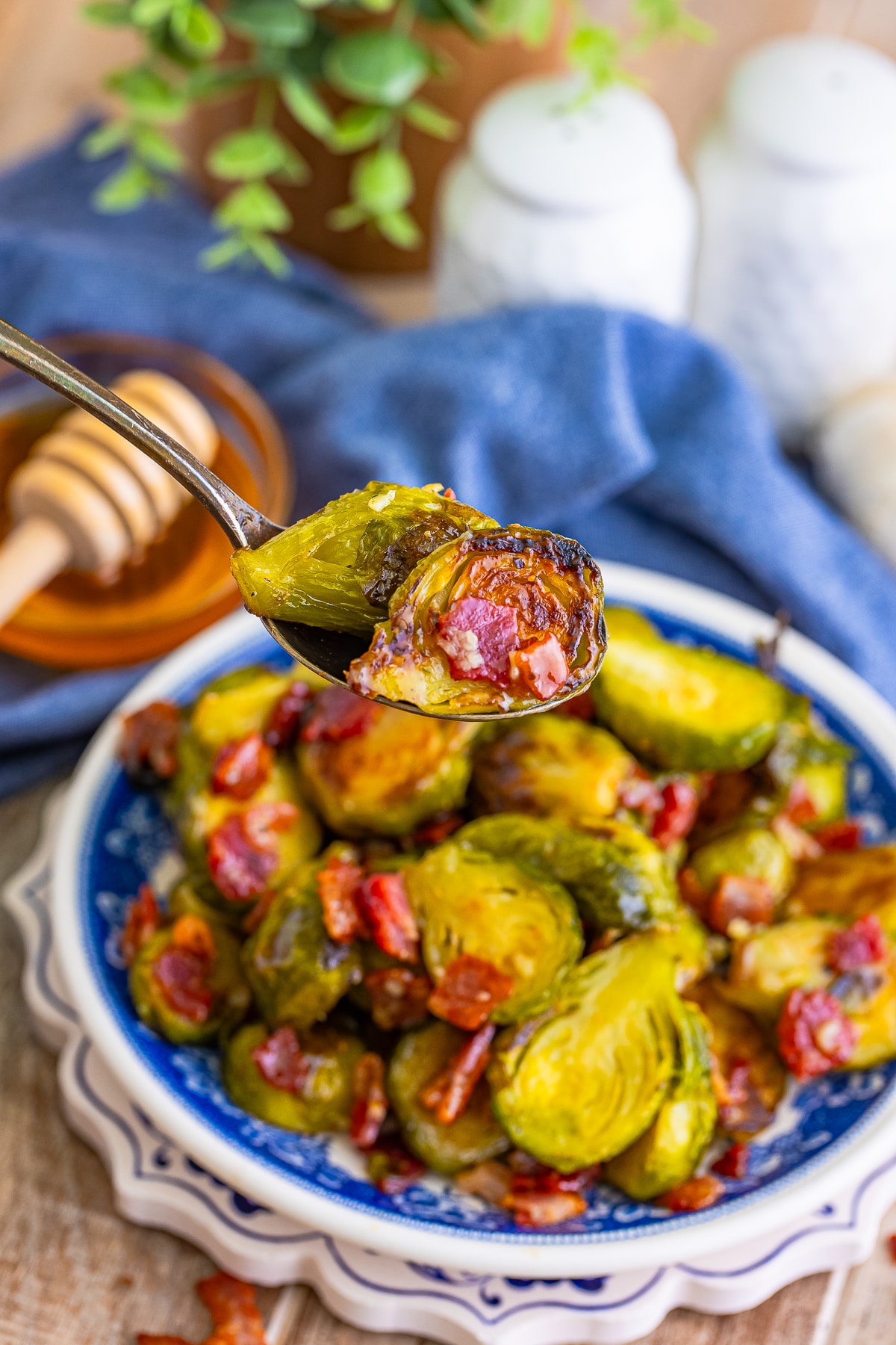 a spoon holding up Brussel Sprouts with Bacon in air