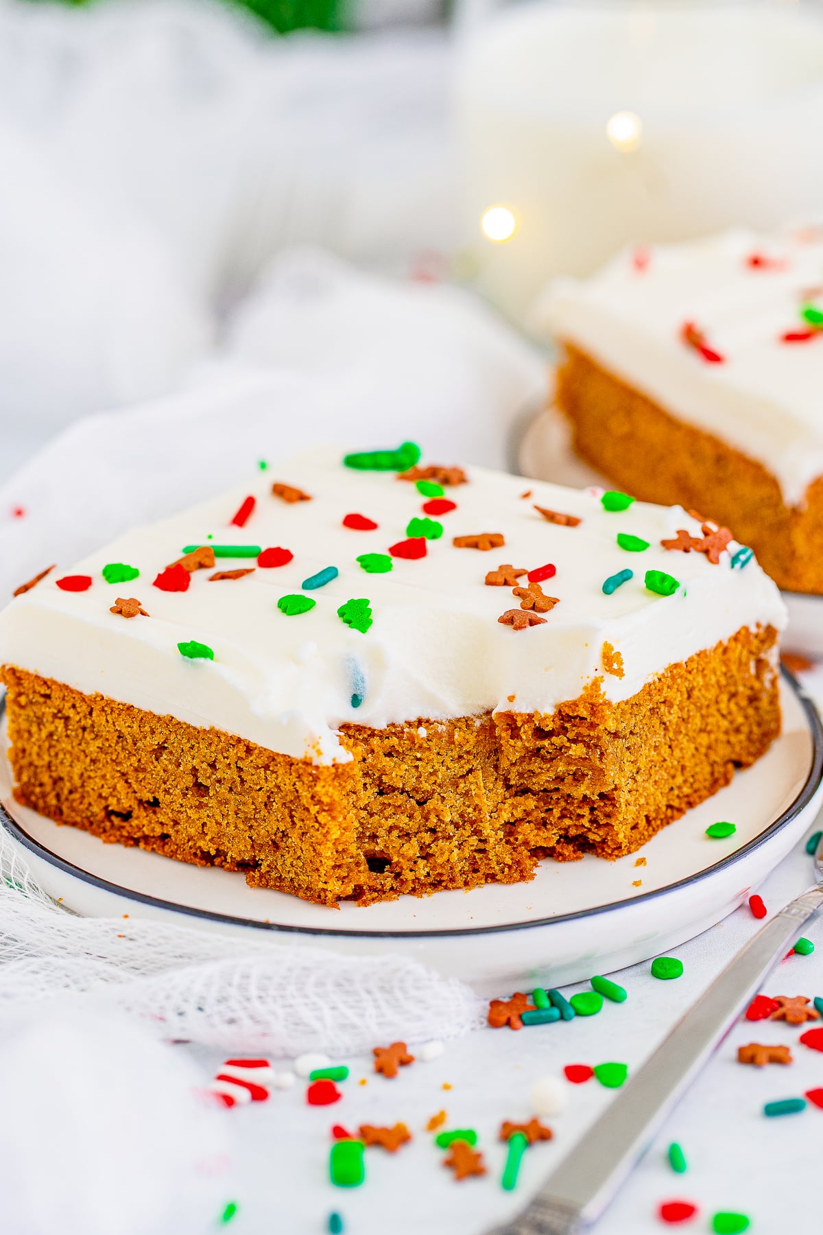 up close image of a bite taken out of Gingerbread Bars on a white plate