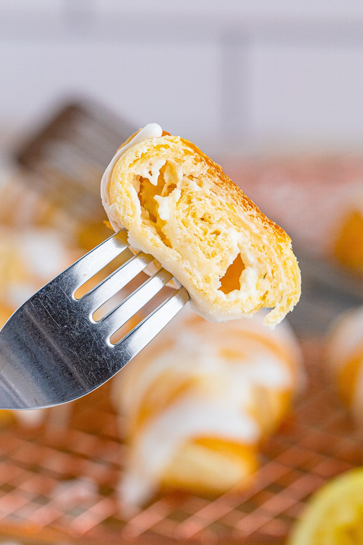 a fork holding up a bite of Lemon Cheesecake Crescent Rolls