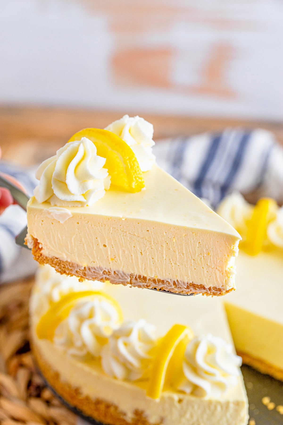 a cake server holding up a slice of Lemon Cream Pie in air