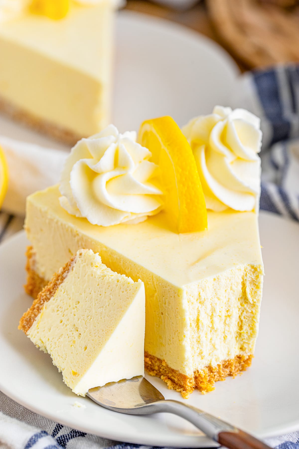 a slice of Lemon Cream Pie on a white plate with a bite taken out