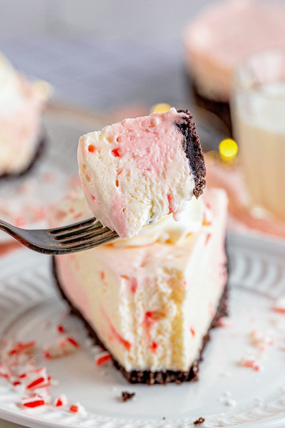 a bite of Peppermint Cheesecake being held up in air with a fork