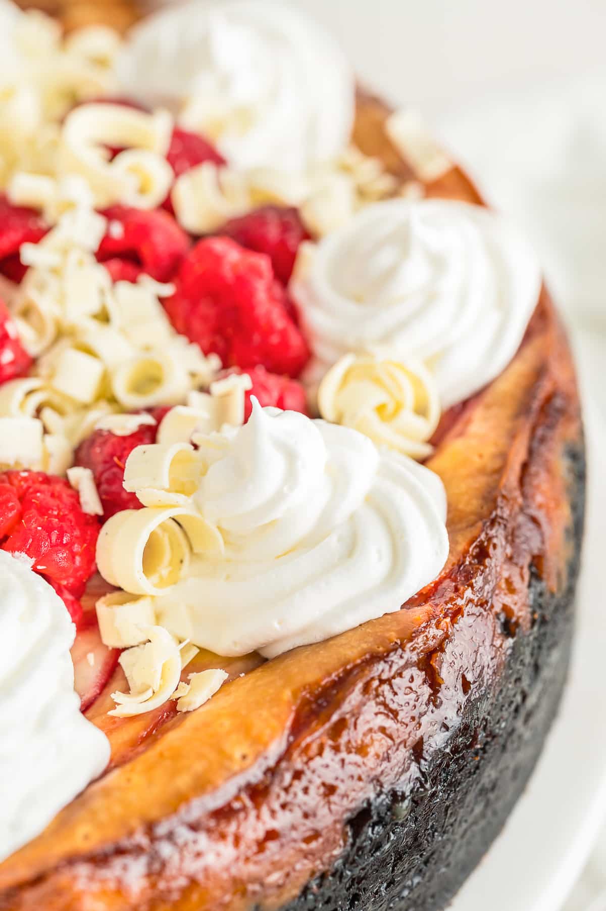 up close image of garnishes on top of White Chocolate and Raspberry Cheesecake