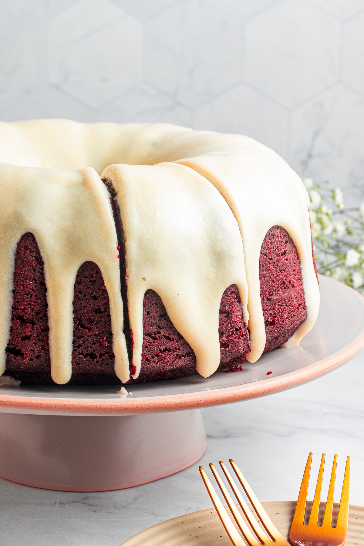 sliced Red Velvet Bundt Cake on cake stand, piece not taken out