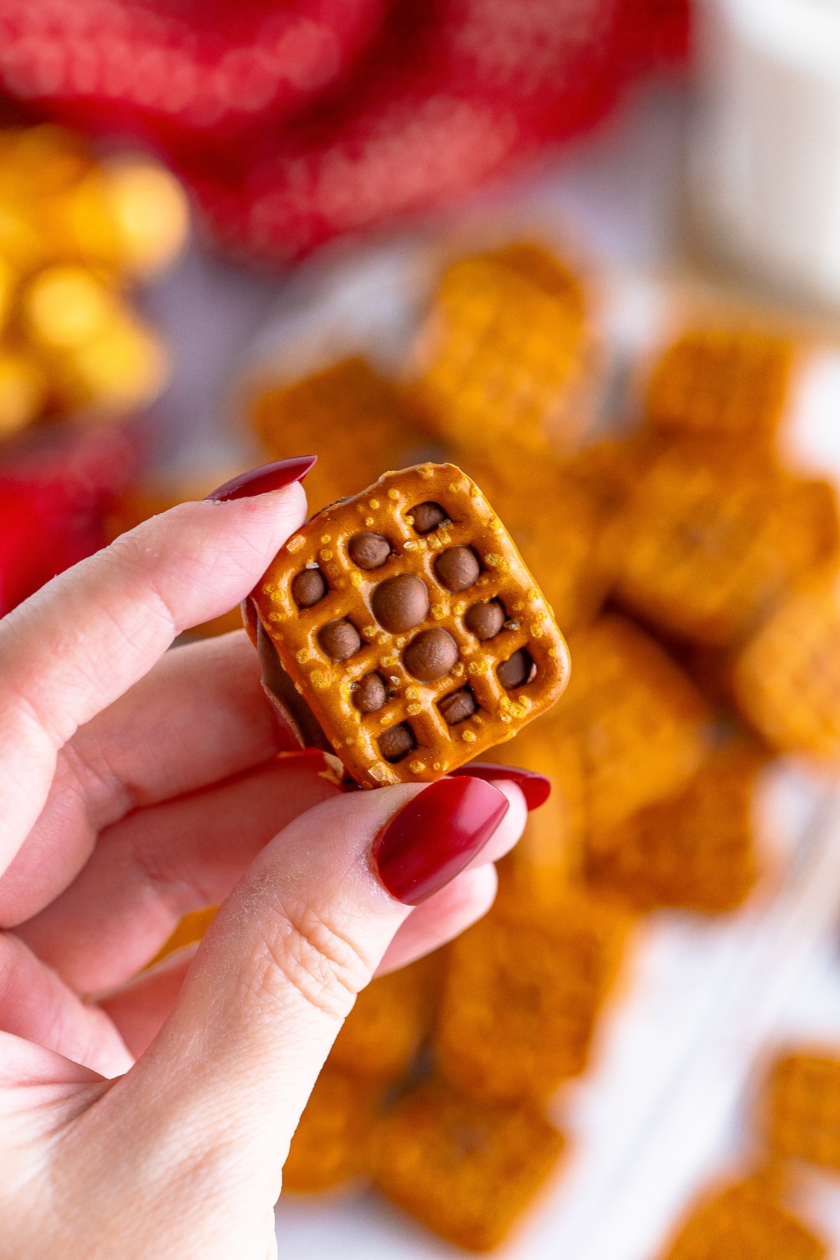 a hand holding up one Rolo Pretzel Recipe in air