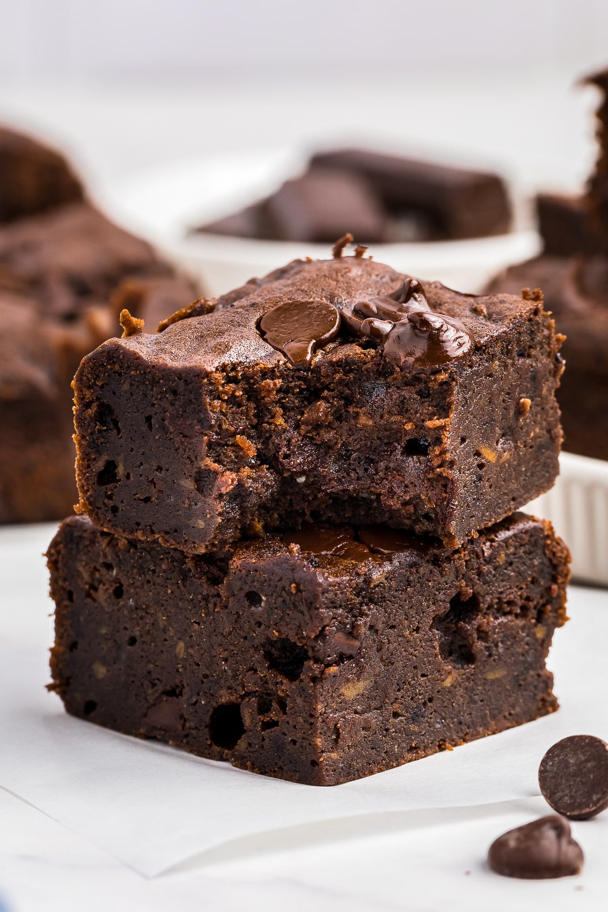 two Sweet Potato Brownies stacked on top of each other, the top one has a bite taken out