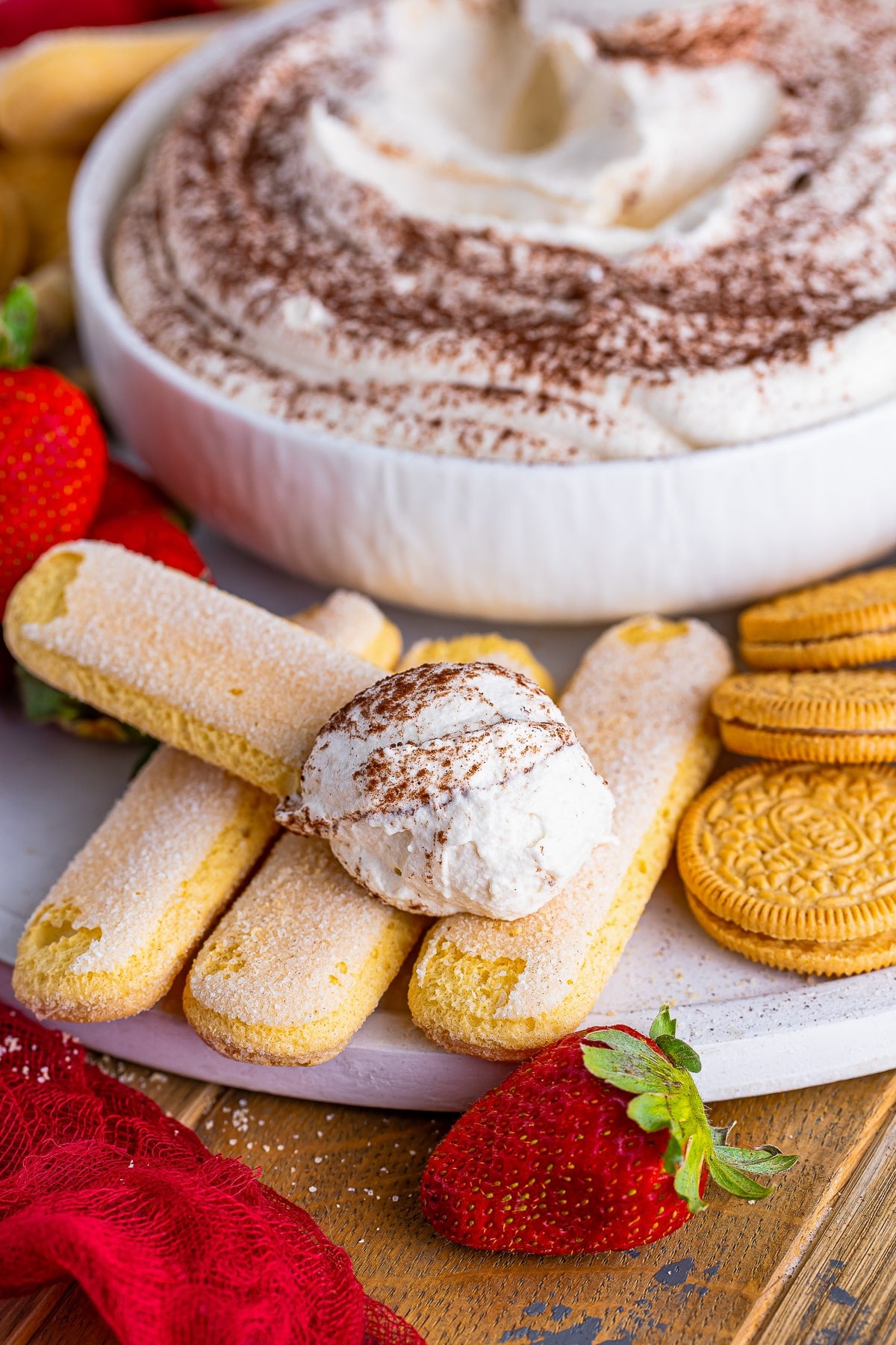 a lady finger with Tiramisu Dip on it resting on more cookies
