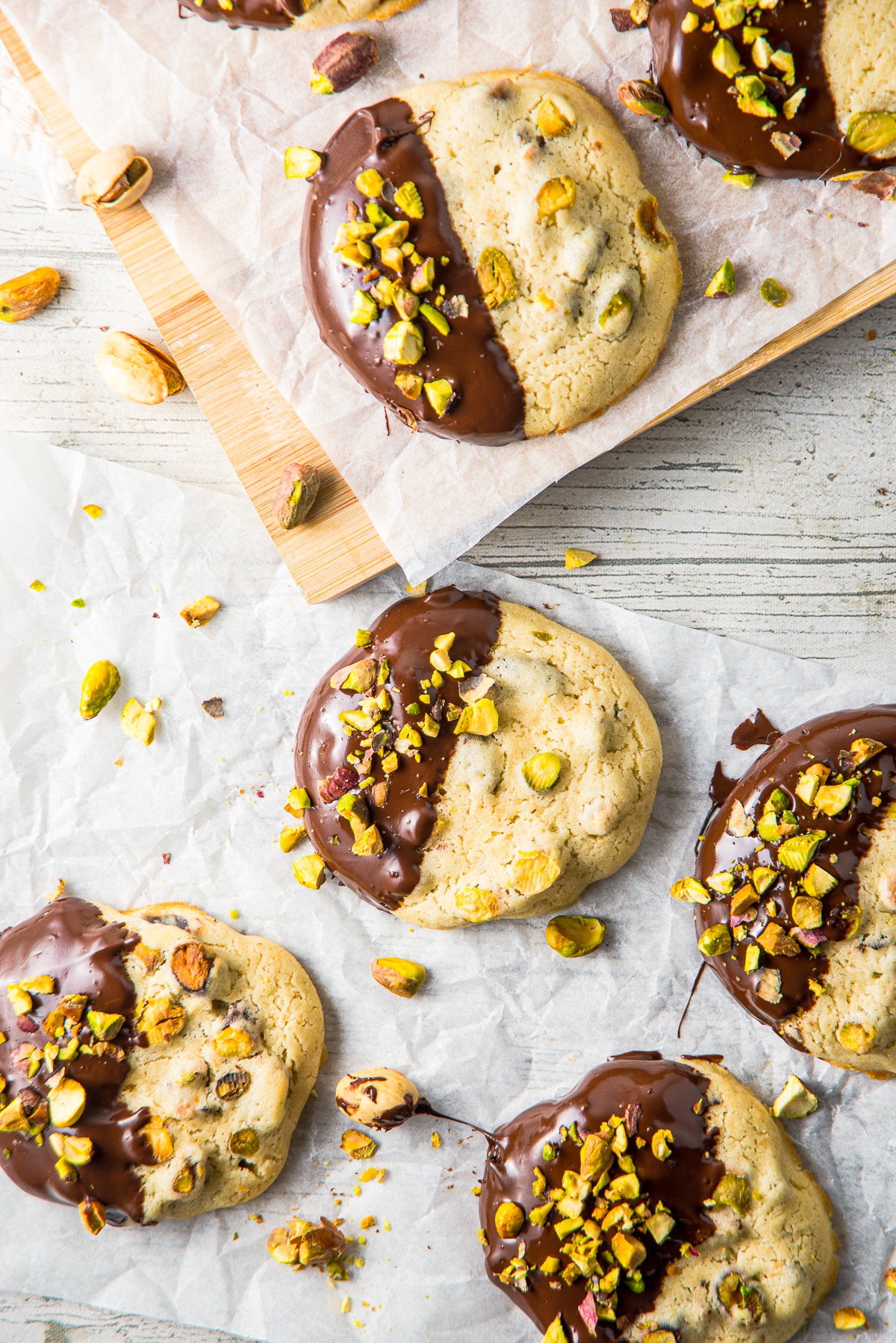 overhead image of a bunch of Pistachio Cookies on parchment paper and a serving board