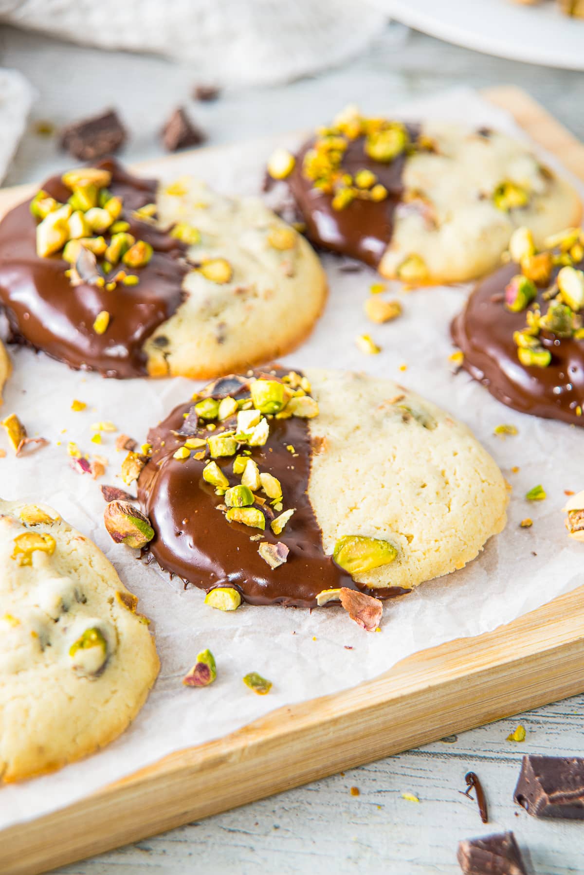 closer image of Pistachio Cookies on a wooden board with parchment paper