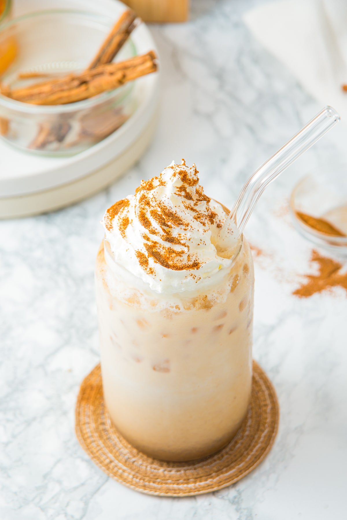 overhead image of Iced Pumpkin Spiced Latte in a tall glass with whipped cream
