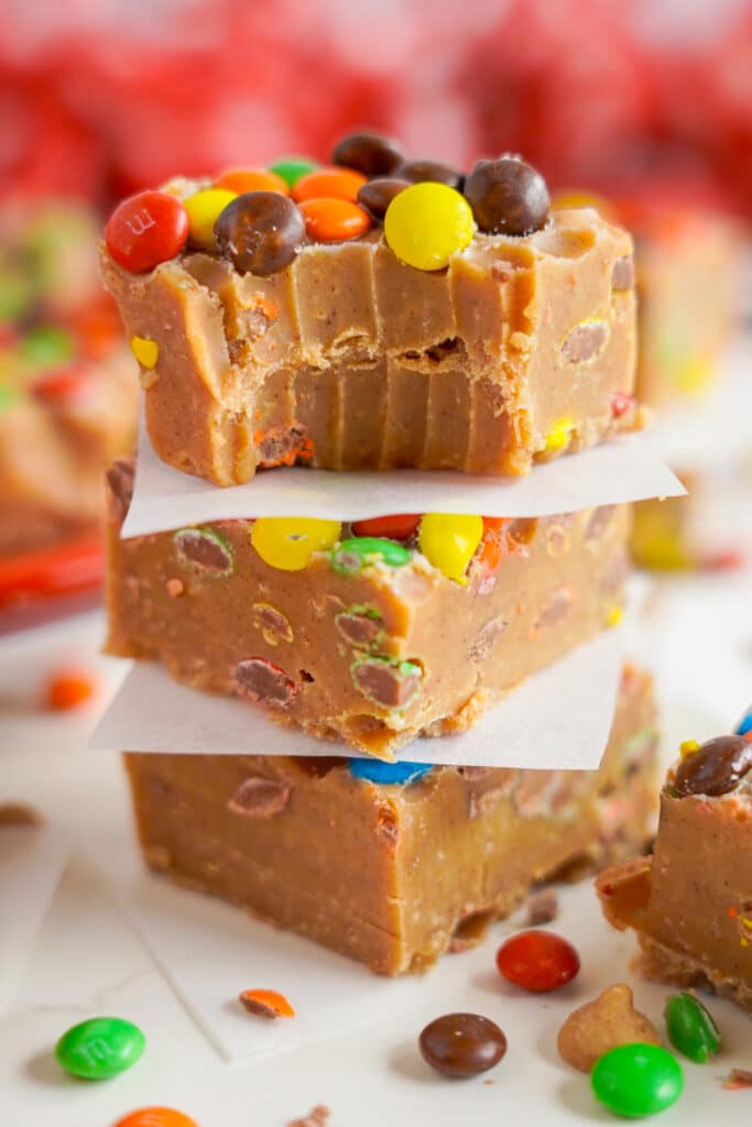 three pieces of Peanut Butter Fudge stacked on top of each other, the one on top has a bite taken out