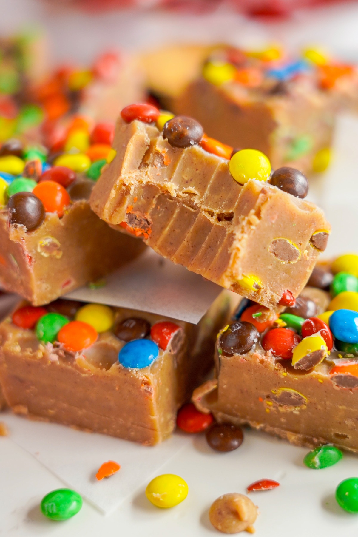 a piece of Peanut Butter Fudge on parchment paper with a bite taken out