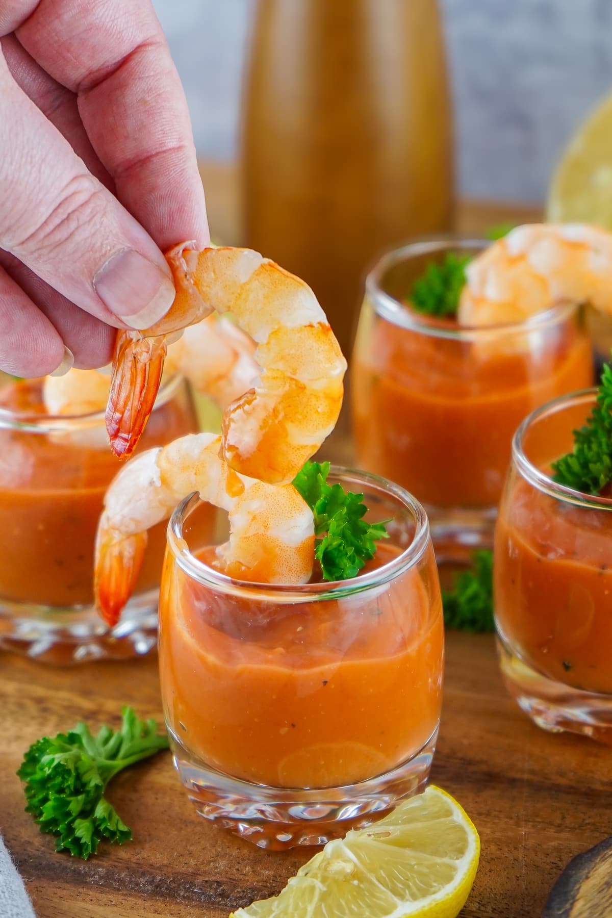 a hand grabbing a Cocktail Shrimp and holding it in air