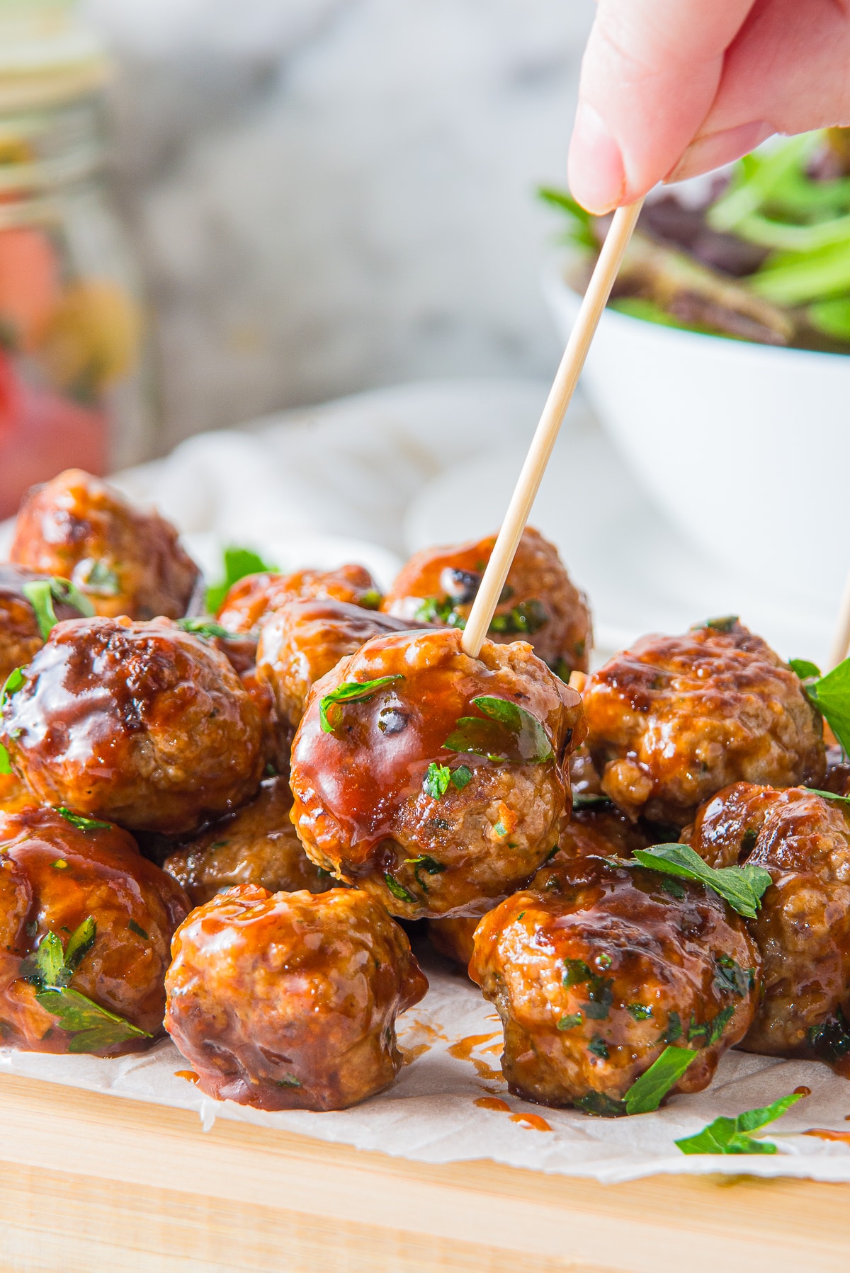 a toothpick in BBQ meatballs on serving board