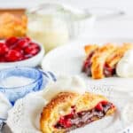 A slice of black forest puff pastry braid with cherries, chocolate, and whipped cream.