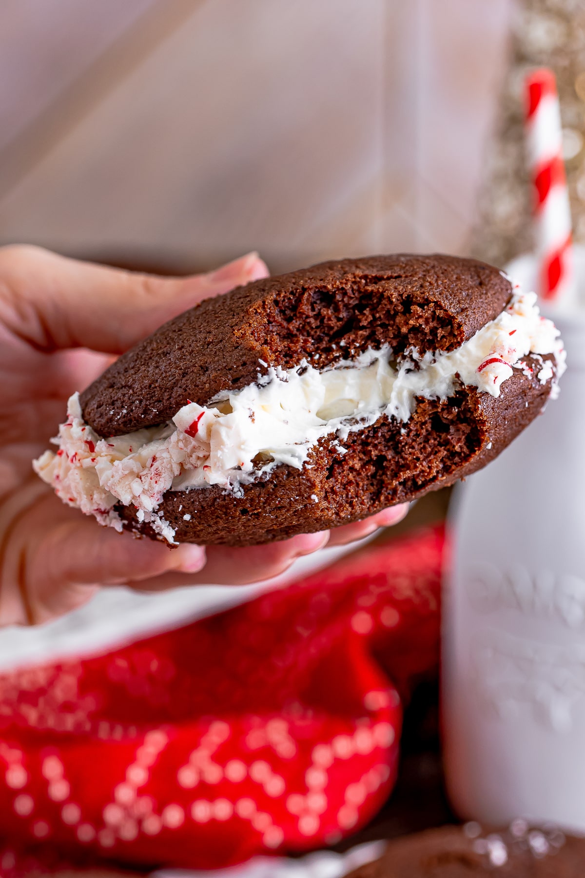 a hand holding up Whoopies Pies in air that has a bite taken out
