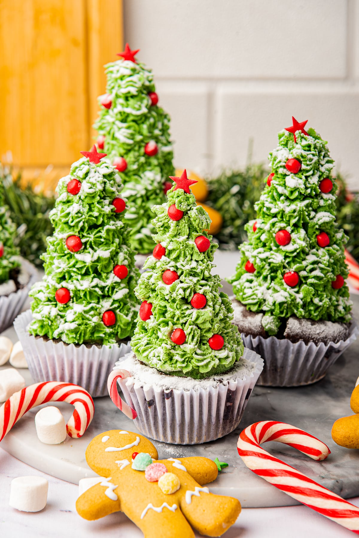 a bunch of Christmas cupcakes on a marble serving platter