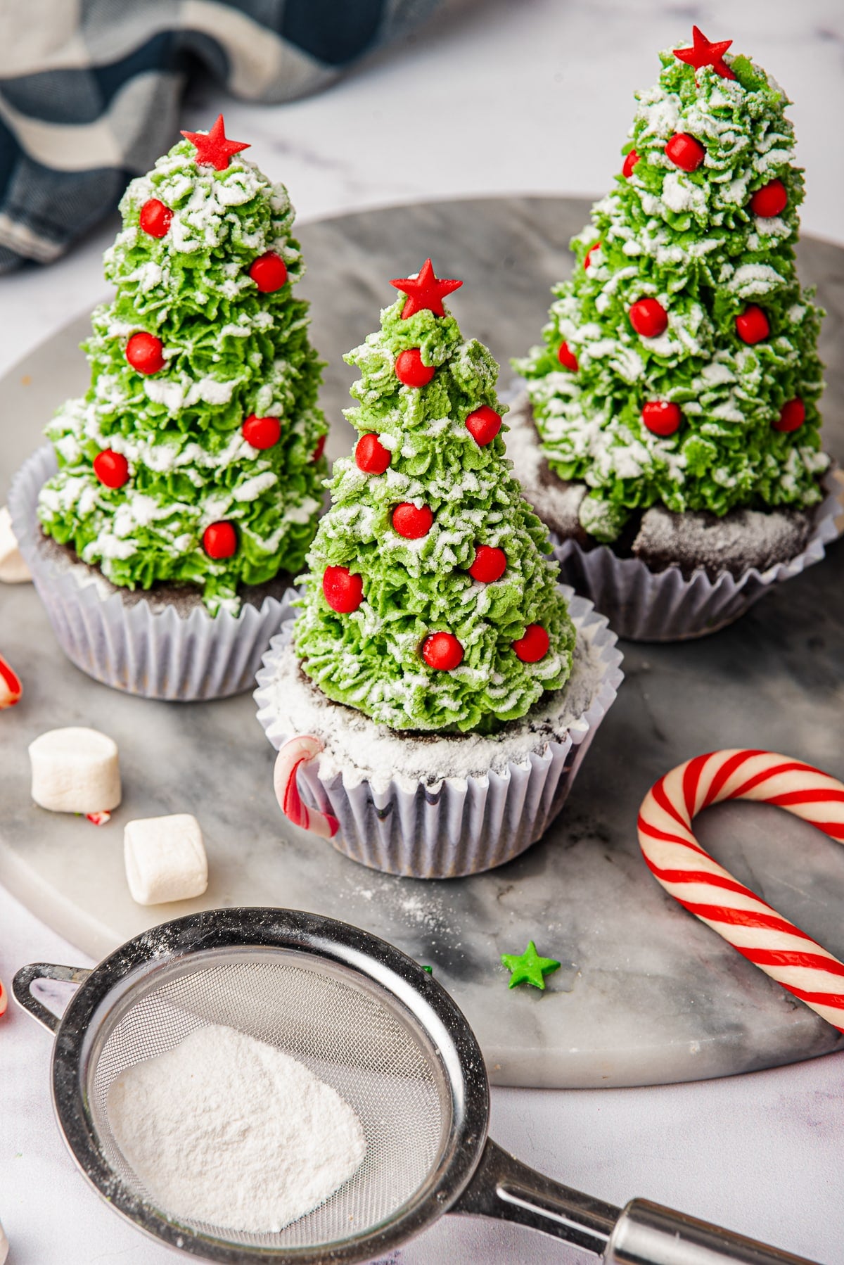 farther away image of finished Christmas cupcakes on a marble slab