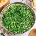 A skillet of rich, creamy steakhouse creamed spinach with shaved parmesan.