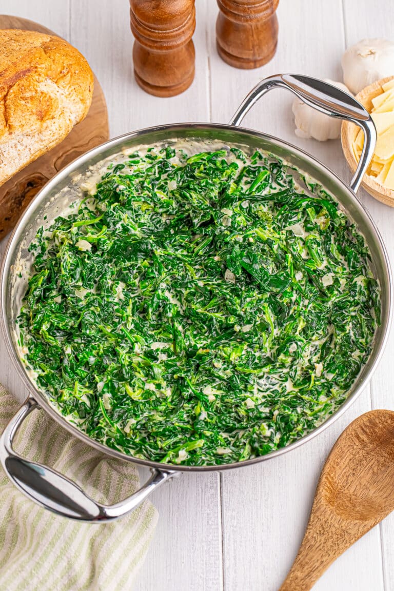 A skillet of rich, creamy steakhouse creamed spinach with shaved parmesan.