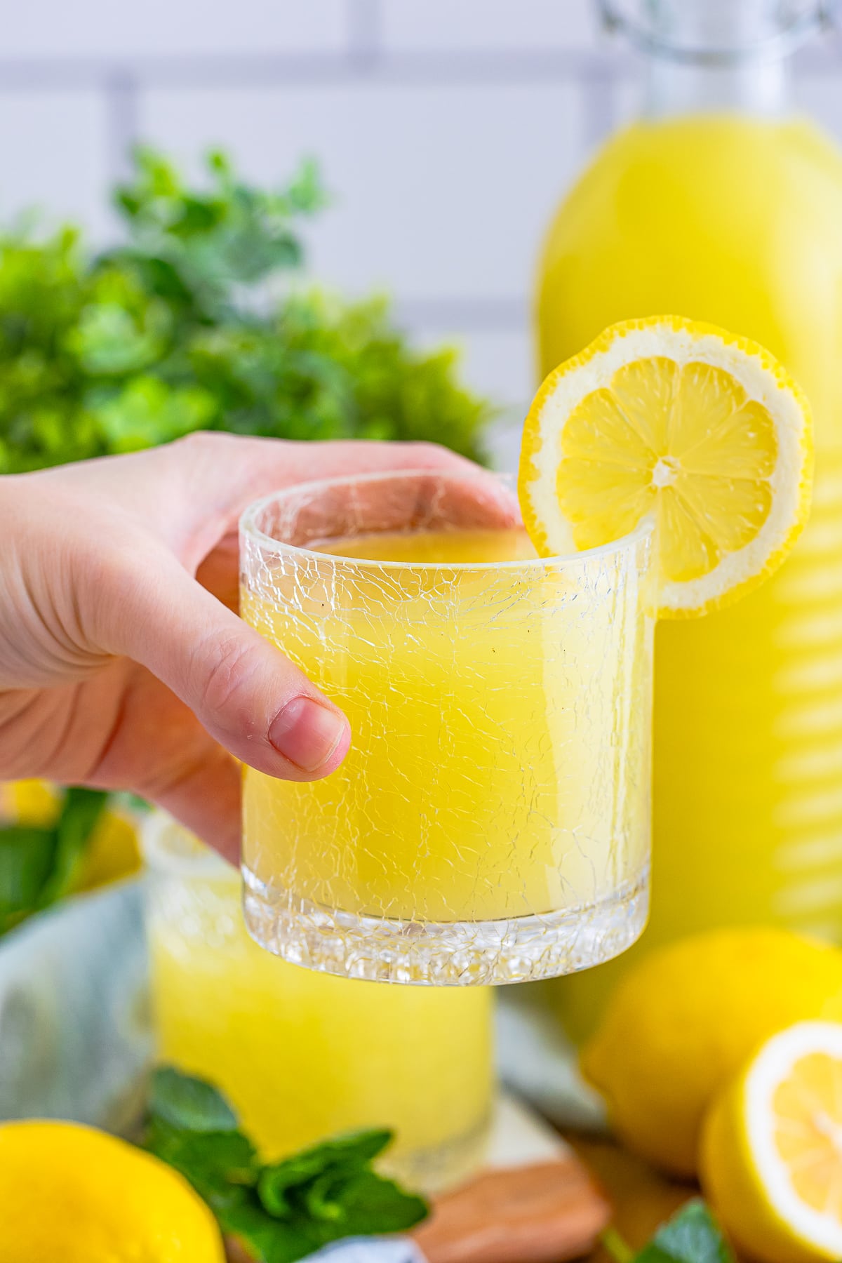 a hand holding up Homemade Limoncello in a glass