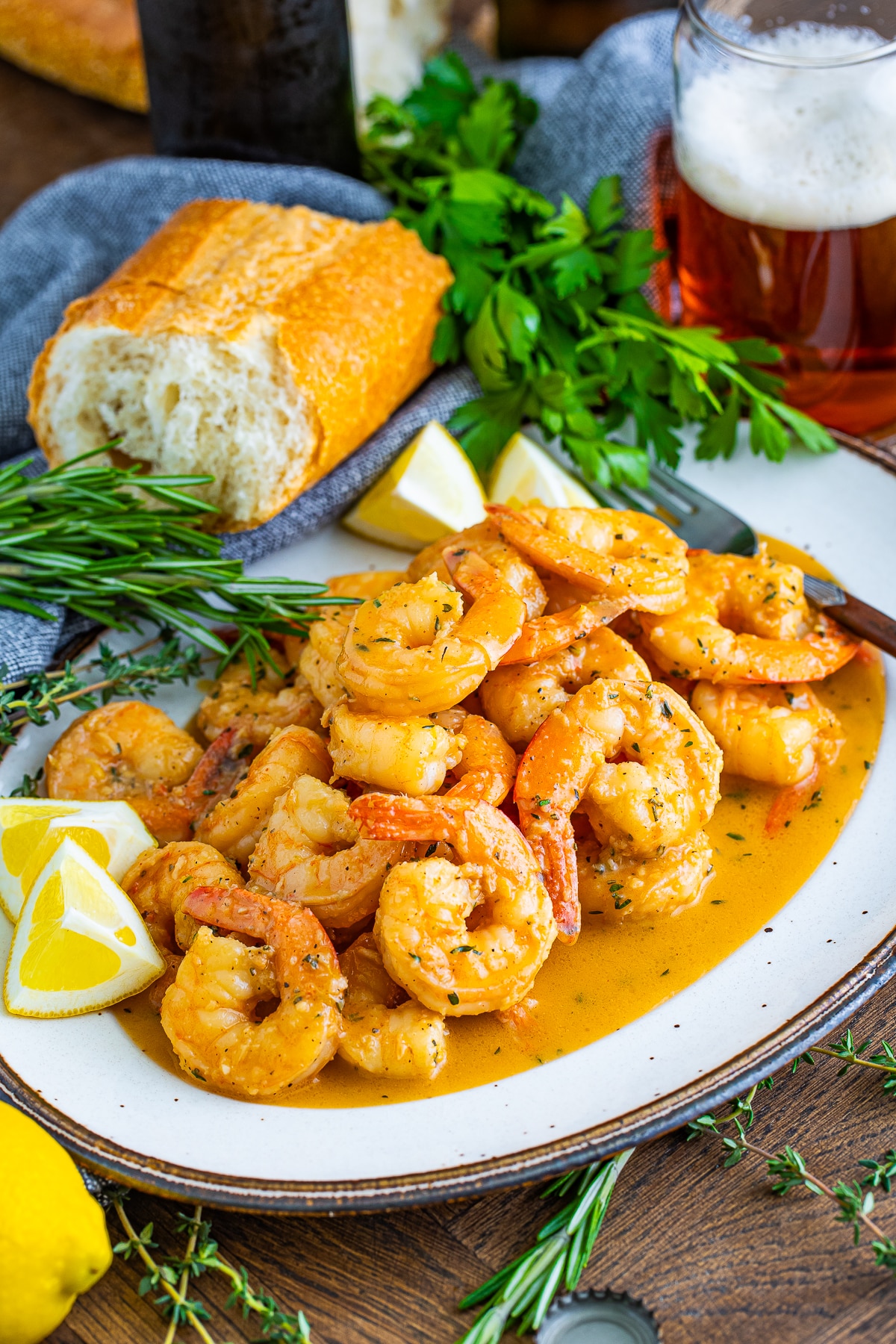 farther away image of finished New Orleans BBQ Shrimp served on a platter with garnishes