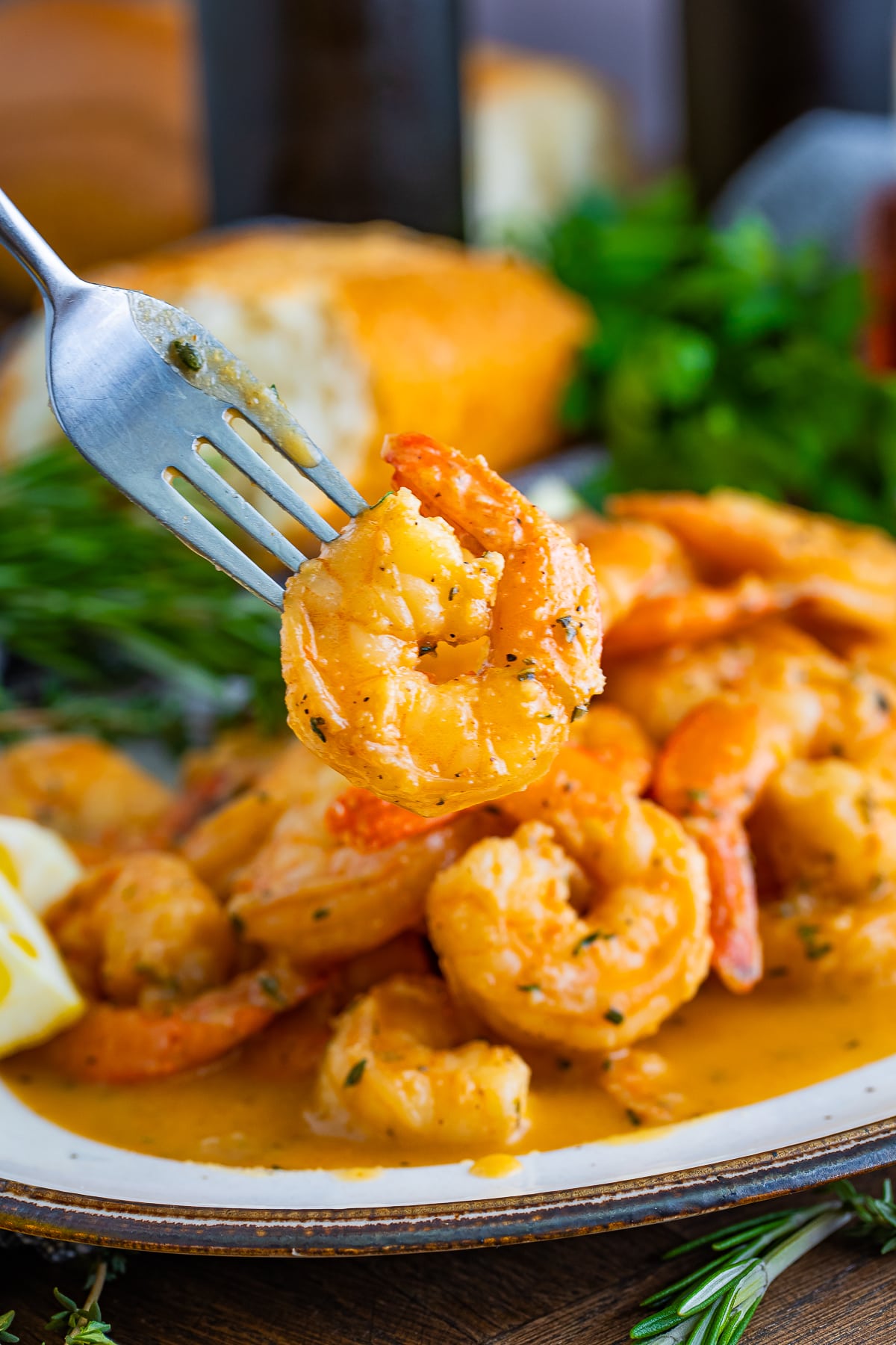 a fork holding up New Orleans BBQ Shrimp in air