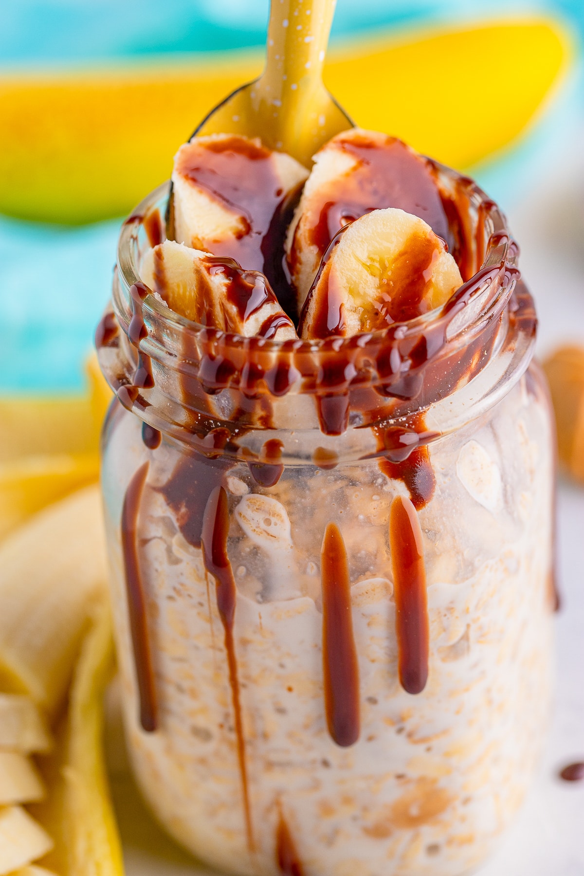 up close image of Peanut Butter Overnight Oats in a mason jar with chocolate syrup