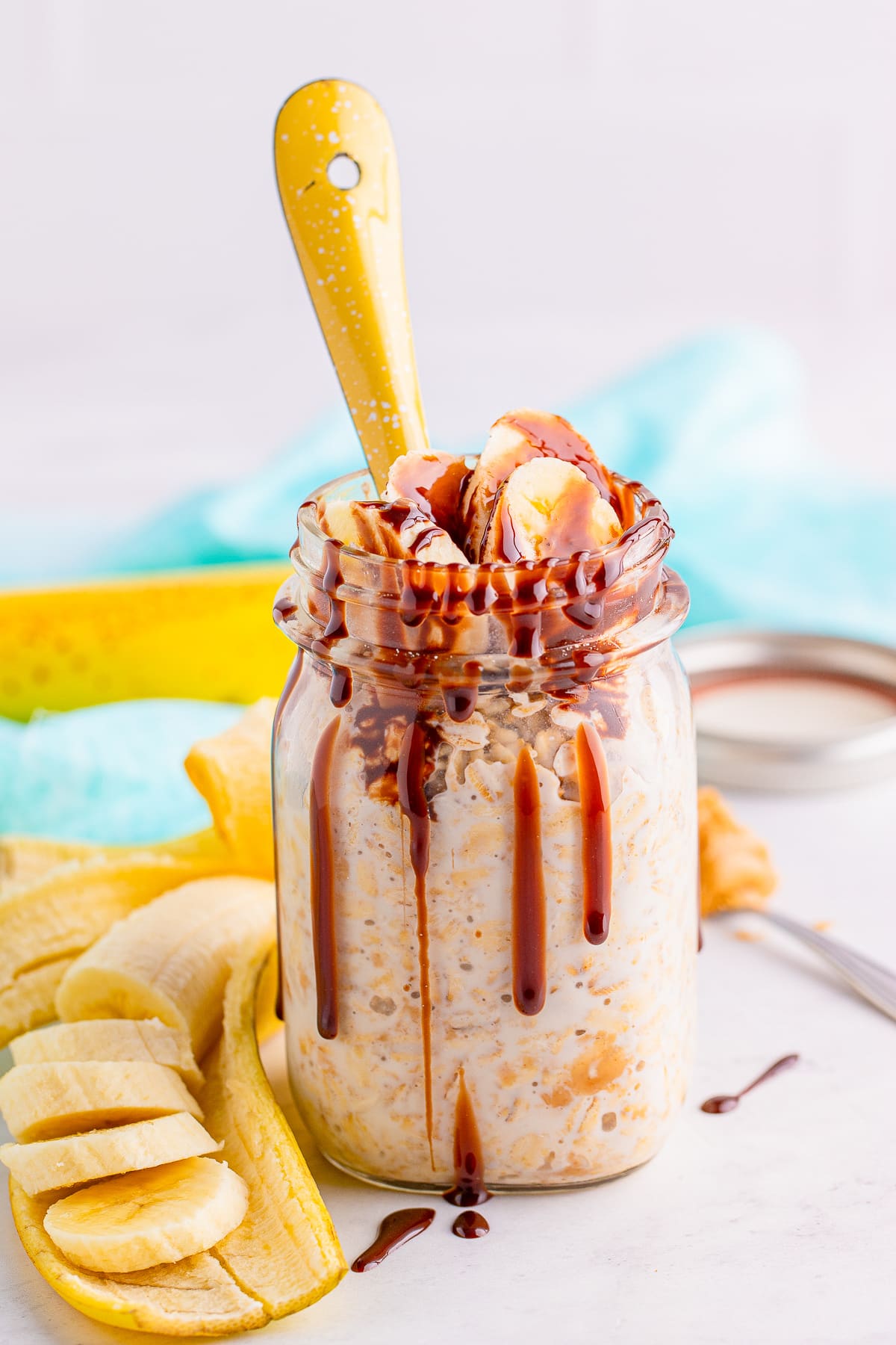 Peanut Butter Overnight Oats in a mason jar with yellow spoon