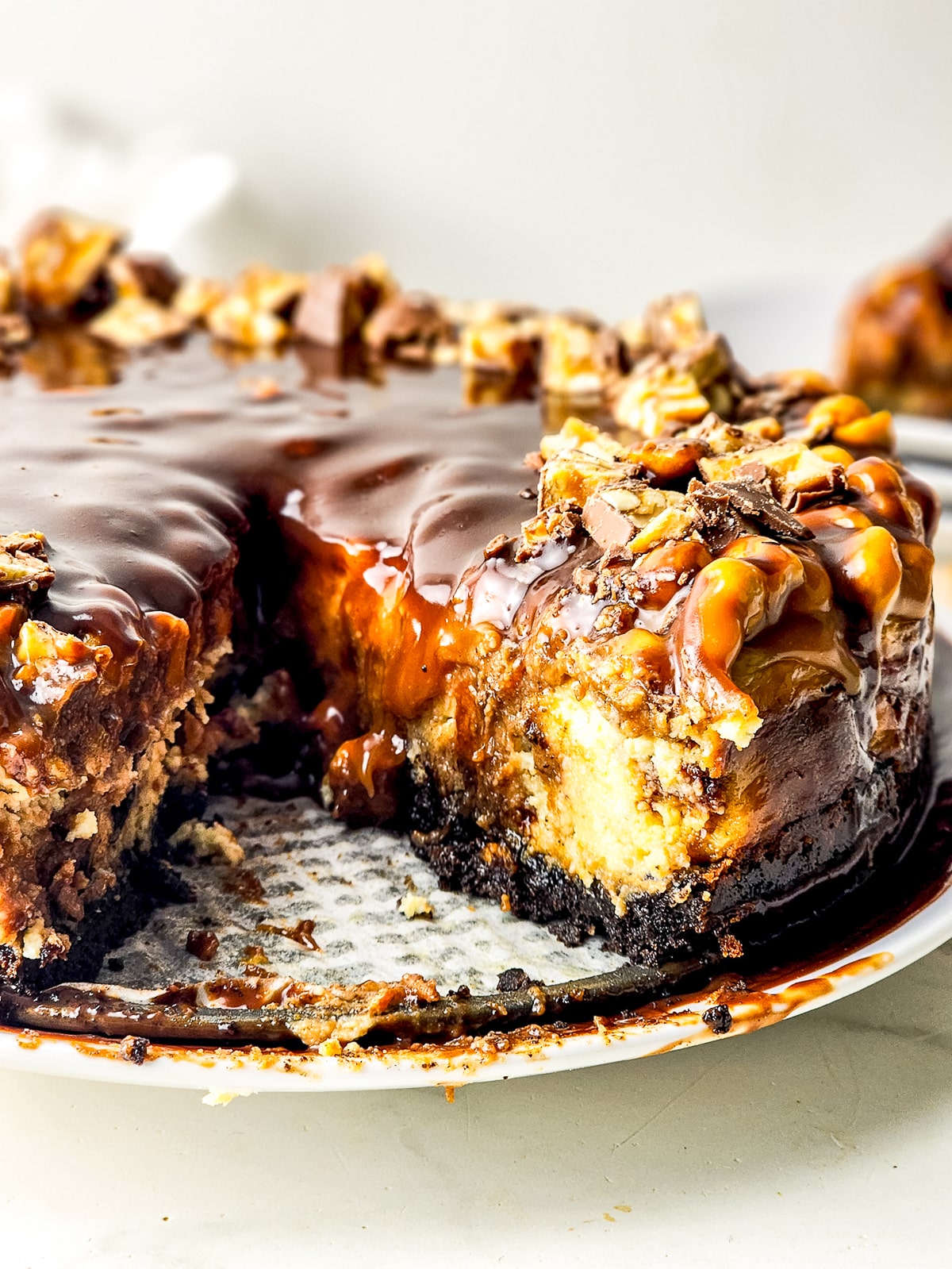 Snickers Cheesecake in the pan with a slice taken out