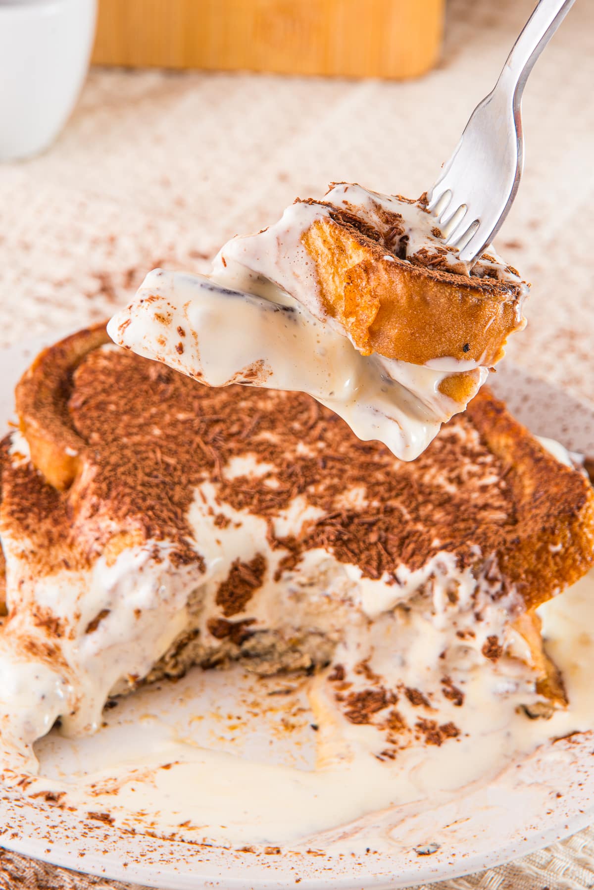 a fork holding up a bite of Tiramisu French Toast in air