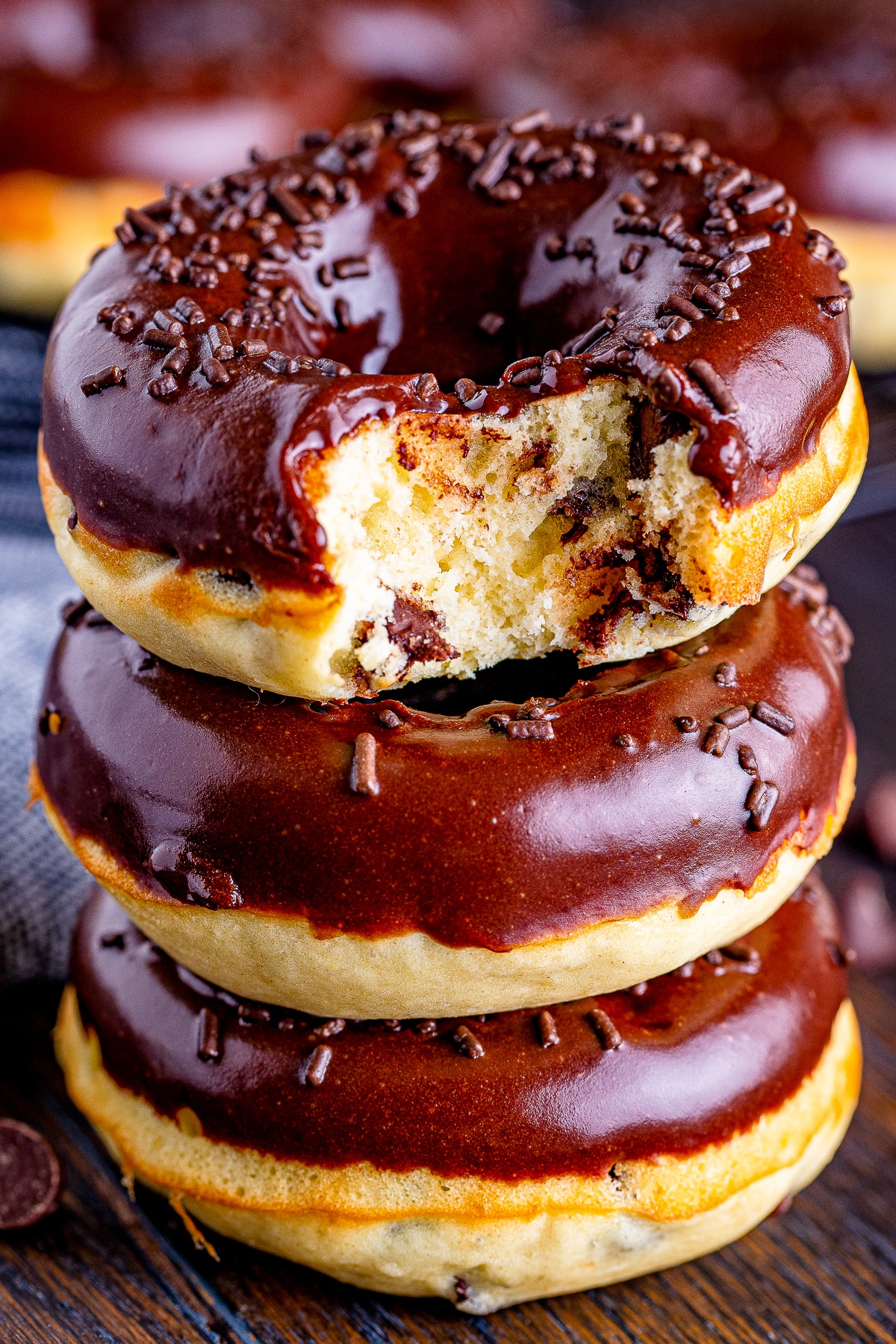 three Cake Donuts stacked the one on top has a bite taken out