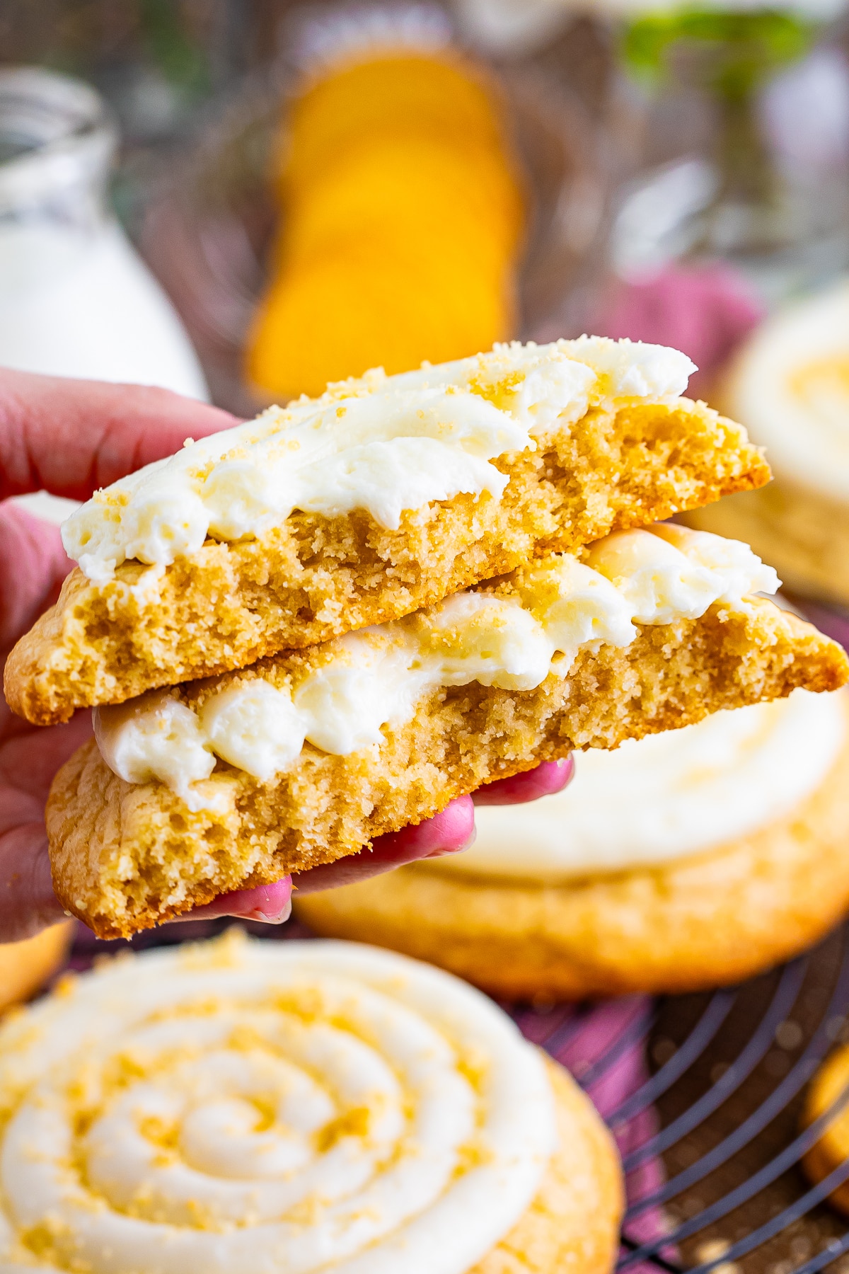 a hand holding up Golden Oreo Cookies in air that has been torn in half