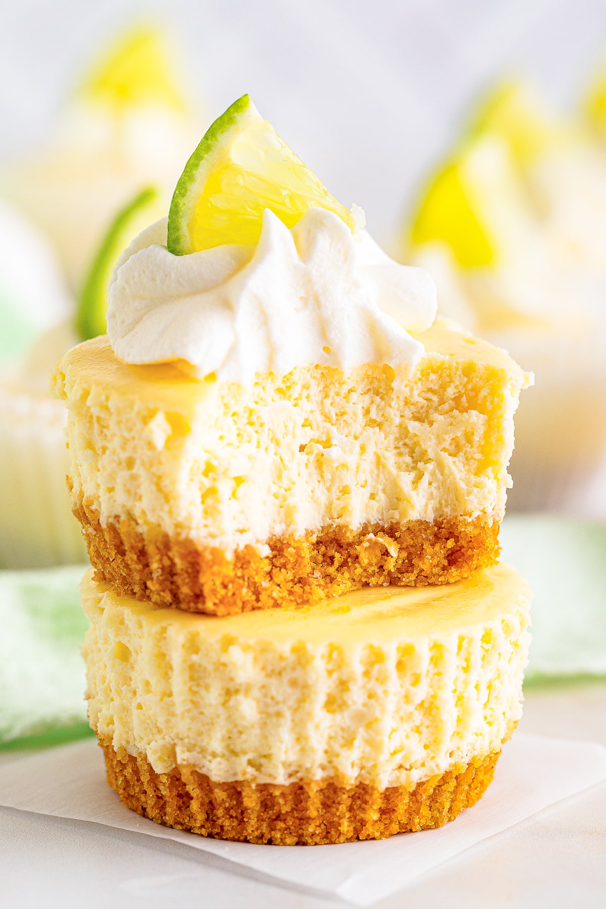 two Mini Cheesecakes stacked on top of each other, the one of top has a bite taken out